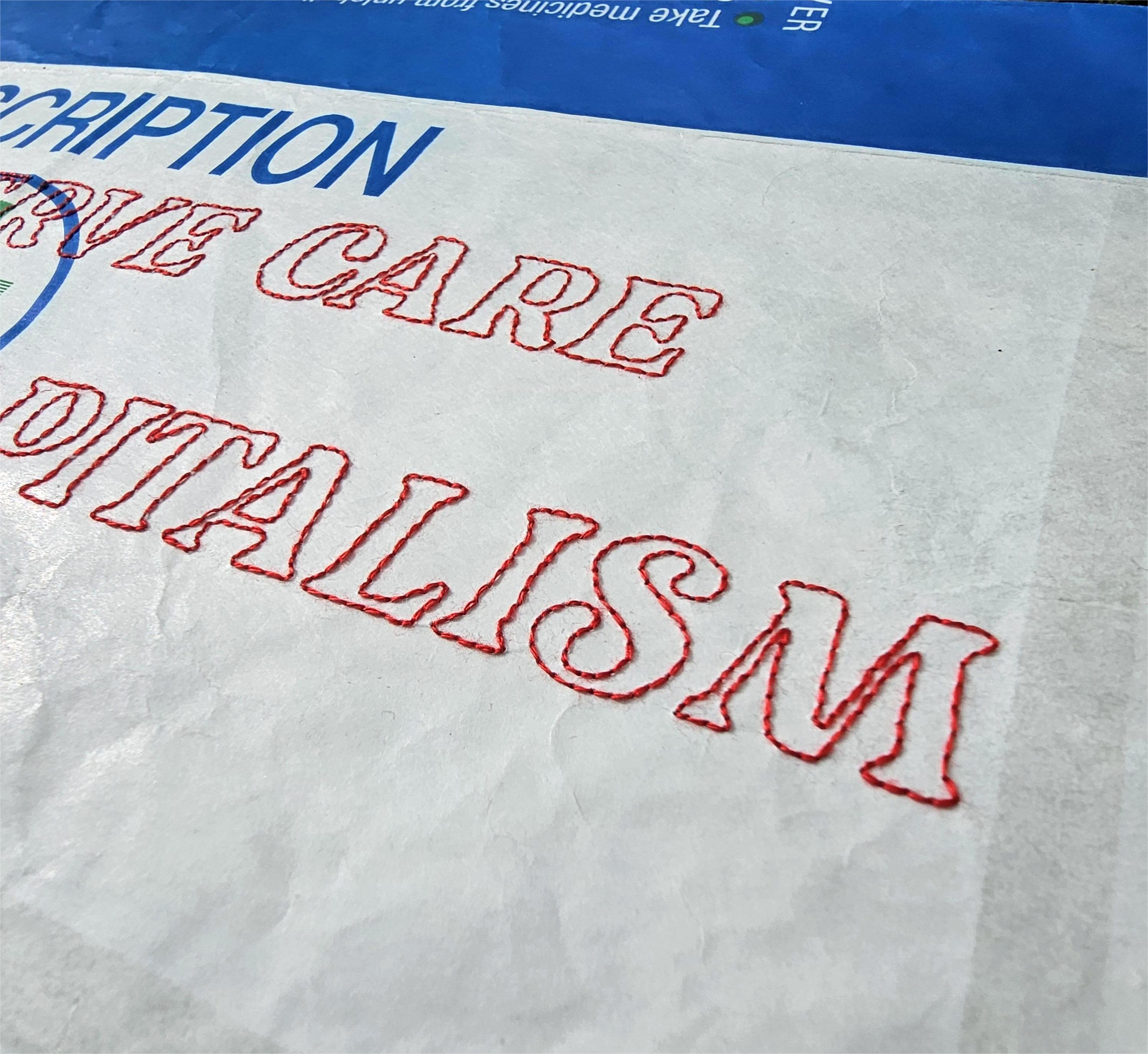 Close up detail of bold capital letters that have been hand stitched onto a prescription bag using red thread and backstitch.