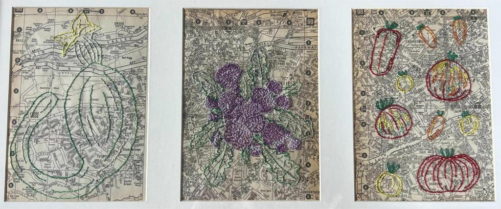 hand embroidery of a tromboncino squash, a purple sprouting broccoli and tomatoes on old maps.